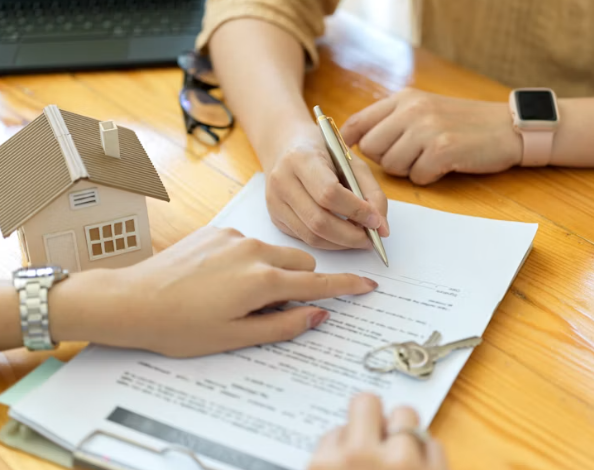 Pessoas analisando e assinando um contrato imobiliário
